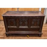 A LARGE CONTINENTAL OAK COFFER, the hinged top above a lunette carved frieze and arched carved three