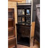 A LATE 19TH CENTURY EBONISED ARTS AND CRAFTS INFLUENCE CORNER CABINET, the mirrored shelved back