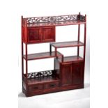 A 20TH CENTURY ORIENTAL STAINED WOODEN DISPLAY STAND, pierced galleried top above stepped shelves,