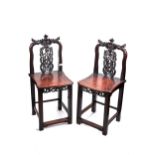 A PAIR OF LATE 19TH/EARLY 20TH CENTURY CHINESE HARDWOOD CHAIRS with foliate pierced splat, solid