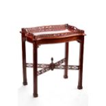 A CHIPPENDALE REVIVAL MAHOGANY SERPENTINE SIDED BUTLERS TRAY ON STAND, the detachable pierced