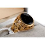 A 9CT YELLOW GOLD AND BLACK ONYX RING with pierced shoulders, stamped 9.375, size K, approximately