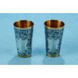 A PAIR OF RUSSIAN SILVER GILT AND NIELLO WORK BEAKERS, stamped 875, 3 ins high.