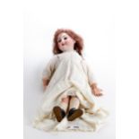 A LATE 19TH/EARLY 20TH CENTURY BISQUE-HEADED DOLL, fixed brown eyes and upper teeth, composition