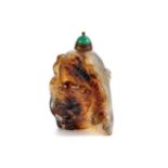 A CARVED MOTTLED AGATE SNUFF BOTTLE with large dragon design to front, green jade stopper, 2 1/4 ins