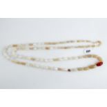 A LONG STRING OF POLISHED STRIATED WHITE AGATE BEADS with central cornelian bead, 40 ins long, needs