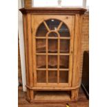 A GEORGIAN PINE FLOOR STANDING CORNER CUPBOARD enclosed by a thirteen pane arched glazed door with