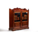A LARGE EDWARDIAN OAK SMOKERS CABINET, twin glazed doors enclosing seven small drawers, shaped