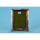 A GEORGE V RECTANGULAR SILVER PHOTOGRAPH FRAME of plain design, oak backed, Birmingham 1922,