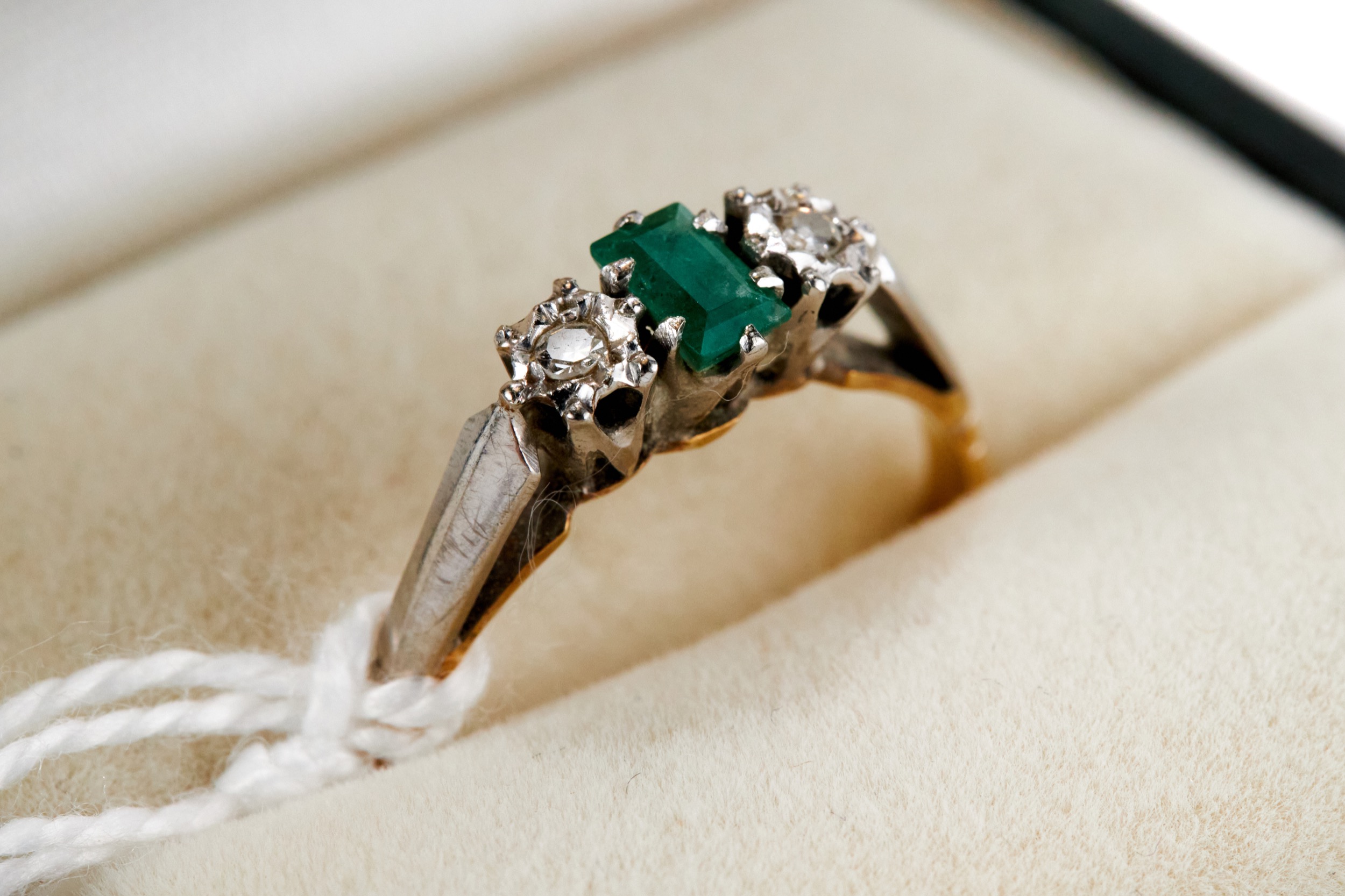 AN 18CT YELLOW GOLD AND PLATINUM THREE STONE EMERALD AND DIAMOND RING, maker: BKT, marks slightly