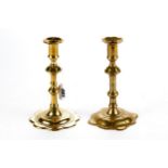 AN 18TH CENTURY BRASS CANDLESTICK with petal edge drip pan, knopped stem on a shaped petal edge