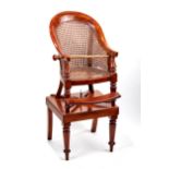 A CHILDS 19TH CENTURY MAHOGANY BERGERE ""JUMP-UP"" CHAIR ON STAND raised on turned legs with