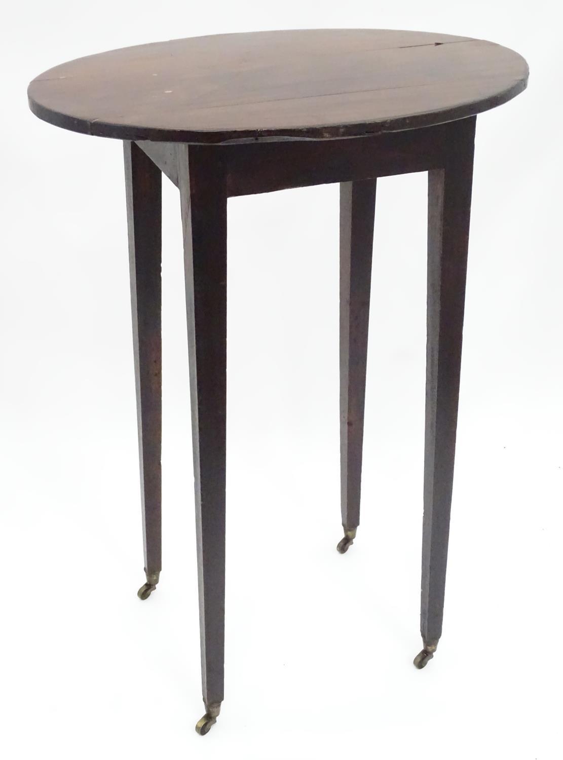 A 19thC mahogany oval occasional table. Approx. 27" tall Please Note - we do not make reference to
