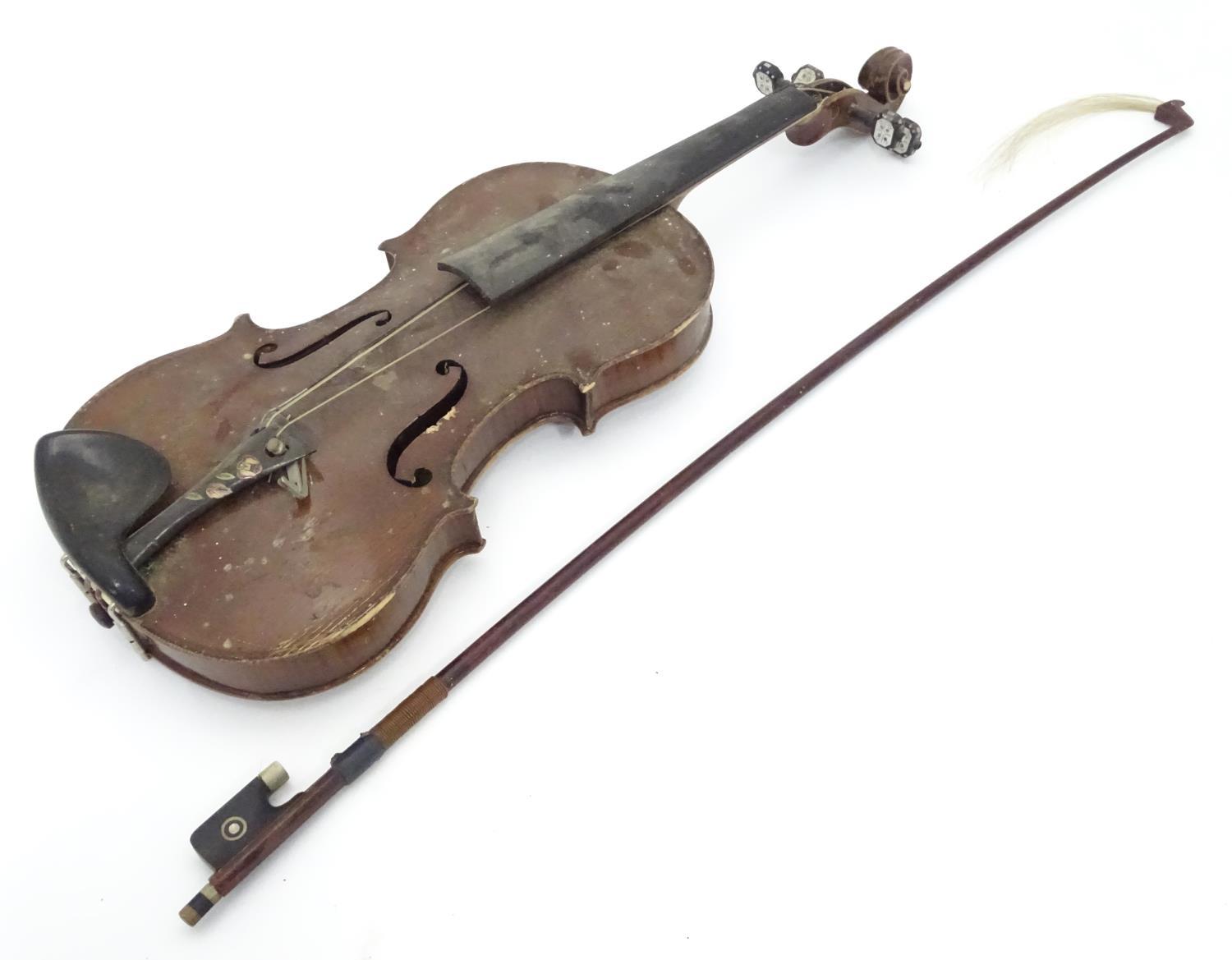 A late 19thC Continental violin with bow Please Note - we do not make reference to the condition