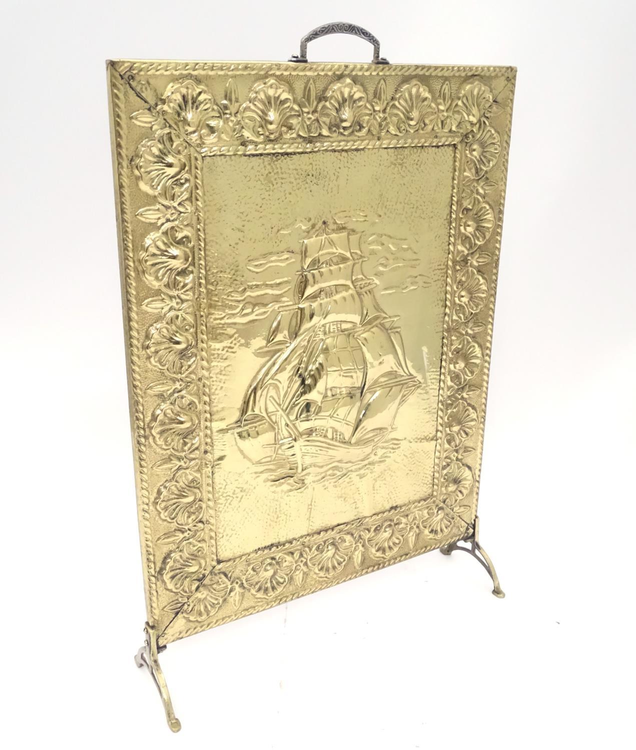 A brass fire guard with ship decoration. Approx. 26 1/2" tall Please Note - we do not make reference