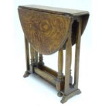 A small oak Sutherland gateleg table. Approx. 19" wide Please Note - we do not make reference to the