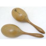A pair of wooden maracas with naive decoration depicting a stylised bird, Panama souvenir. Approx.