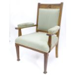 An early 20thC oak framed upholstered open armchair Please Note - we do not make reference to the