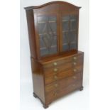 An early / mid 19thC mahogany secretaire bookcase, having a curved pediment above two glazed doors