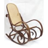 A 20thC rocking chair with bentwood frame and rattan seat Please Note - we do not make reference