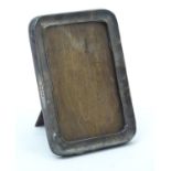 A silver mounted photograph frame with wooden back and easel-style mount. Hallmarked Birmingham 1923