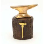 An early 20thC small proportion brass model anvil mounted on a tree stump base with hammer.