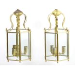 A pair of pendant lights of brass lantern form with 6 bevelled glass panels and three branches