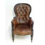 A mid / late 19thC spoon back armchair with a moulded surround and a deep buttoned leather backrest,