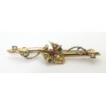 A late 19th / early 20thC 9ct gold and gilt metal bar brooch with butterfly decoration to centre set