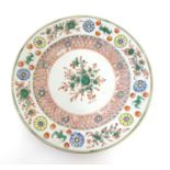 A Chinese plate with central floral and foliate detail, with a patterned border with flowers and