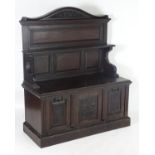 A late 19thC oak hall cupboard with a shaped upstand and carved pediment above a panelled back