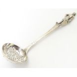 A silver sifter ladle the finial formed as a knight with shield, hallmarked London 1885. 6" long