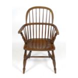 A 19thC elm and ash Windsor chair with a double bowed back above a shaped seat and standing in