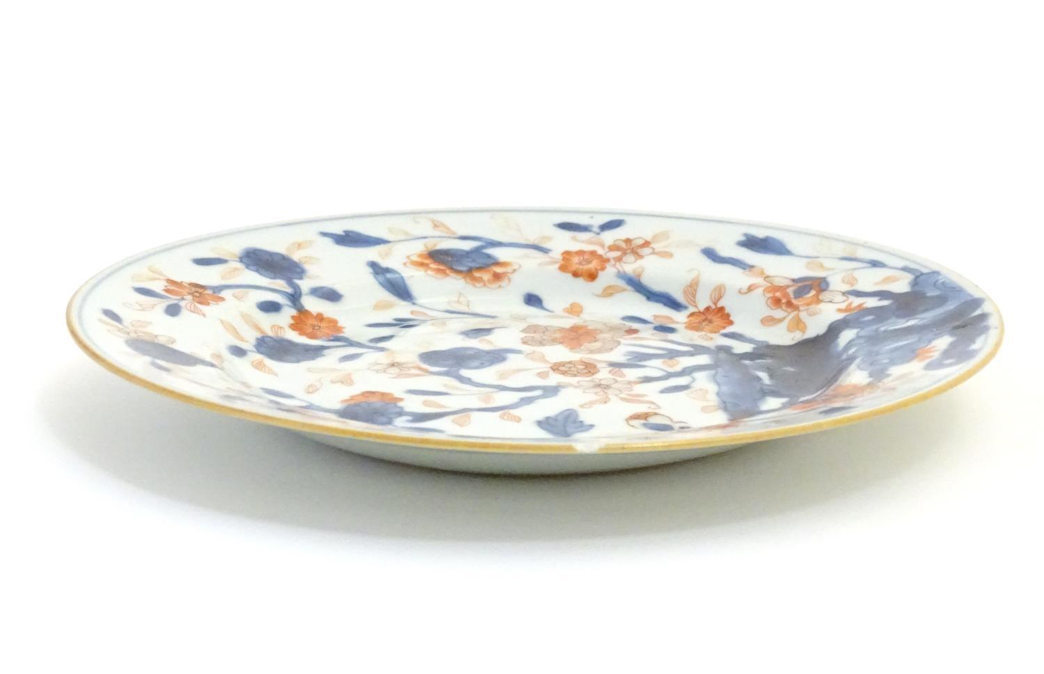 A Japanese plate in the Imari palette with hand painted decoration depicting blossoming flowers. - Image 4 of 4