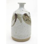 A studio pottery vase with brush work detail by Russell Anthony Collins. Impressed maker's mark to