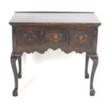An early 20thC oak Georgian style lowboy with a rectangular top above three short drawers with