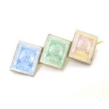 A vintage gilt metal brooch set with enamel decoration depicting three British Guiana stamps.