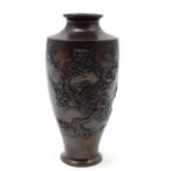An Oriental cast baluster vase with a stylised landscape scene depicting a tree, flowers and a