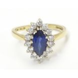 A 14k gold ring set with central sapphire bordered by white stones. Ring size approx N 1/2 Please