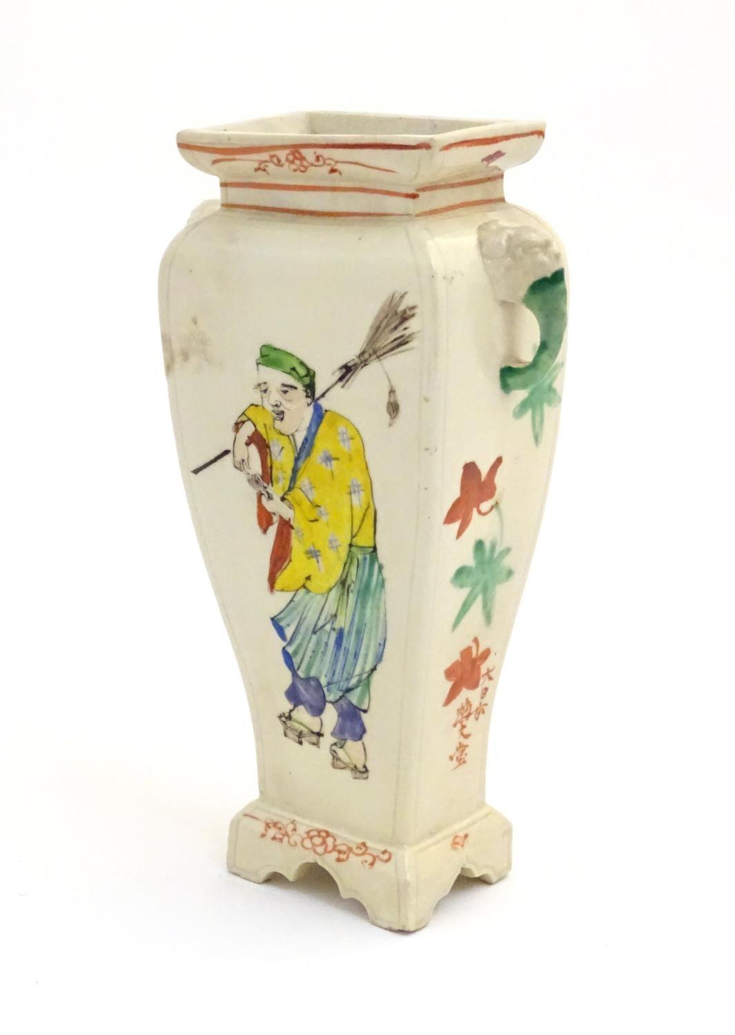 An Oriental vase with twin handles of elephant head form. The body with hand painted figures and