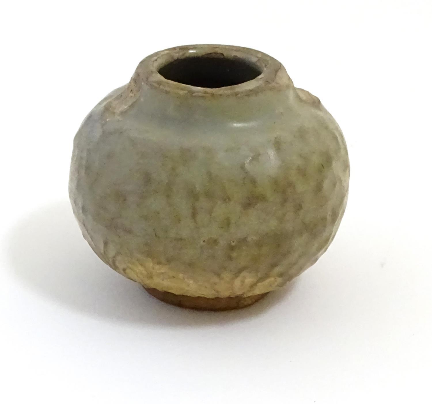 A small Chinese celadon pot with stylised leaf detail in relief. Approx. 2 1/2" high Please Note -