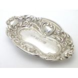 A silver pin dish of oval form with embossed decoration. Hallmarked Birmingham 1982 maker W I