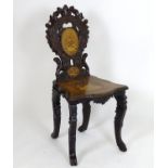 A late 19thC Black forest chair of walnut construction, having a floral carved frame and marquetry