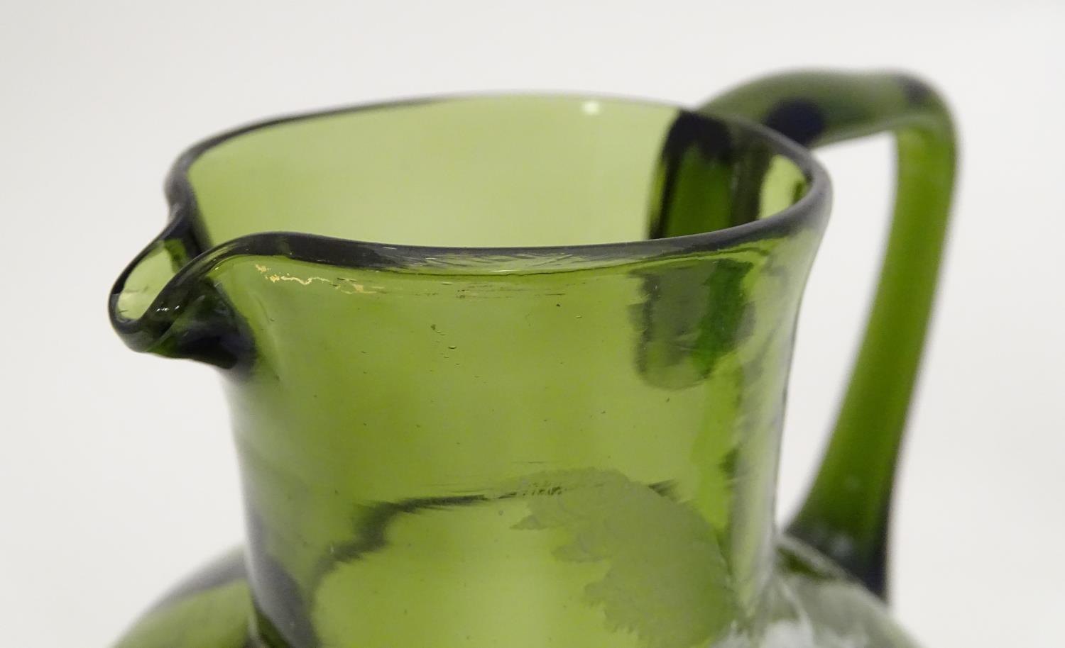 A Victorian olive green glass jug with Mary Gregory style decoration together with a green glass - Image 3 of 7