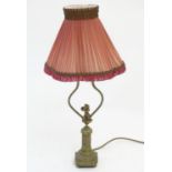 A mid to late 20thC brass table lamp, formed as a Corinthian column surmounted by a putto. 22"