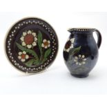 Two items of Continental studio pottery comprising a jug and a plate with floral and foliate detail.
