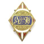 A gilt metal brooch with engraved acanthus scroll, and enamel detail with central monogram. 2"