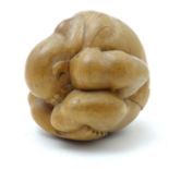 A carved wooden sumo wrestler rolled in a ball. Approx. 3" Please Note - we do not make reference to