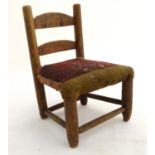 A Victorian doll's chair of elm construction with a tapestry upholstered seat. Approx. 12 1/2" high.