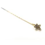 A 9ct gold stick pin surmounted by stylised maple leaf decoration set with seed pearls. Approx 2"